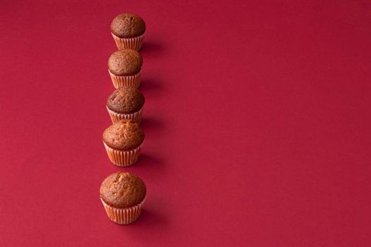 vanilla mini muffins on a red background. Place for your text. Cupcake pattern. Fresh cupcakes. High quality photo