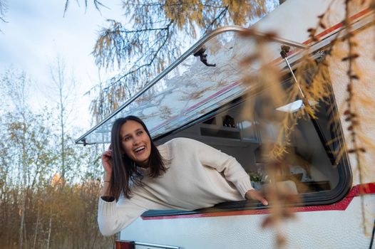 Caucasian woman peeking out of camper window