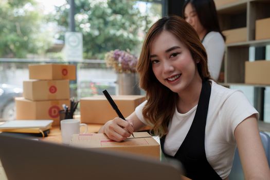 Asian SME business woman with partner working at home office. online shopping concept.