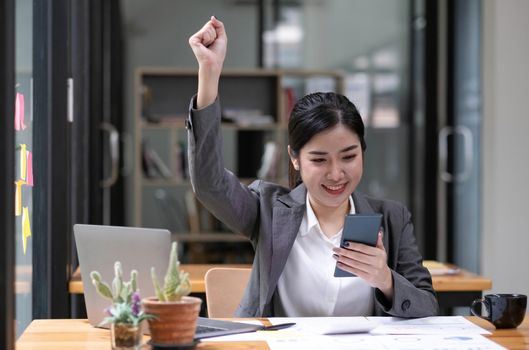 Asian business women are delighted and happy with their work on the phone and taking notes at the office..