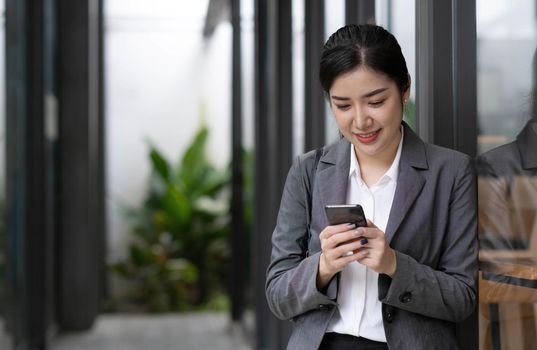 Portrait of a beautiful smiling woman using a mobile phone outdoors.