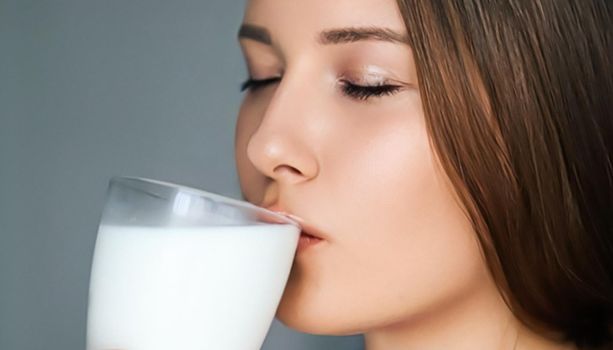 Diet and wellness, young woman drinking milk or protein shake cocktail, portrait