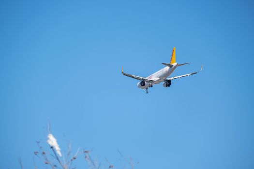 Commercial airplane flying high in clear blue sky