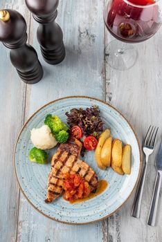 Grilled chicken breast in different variations with cherry tomatoes and different vegetables on wooden background