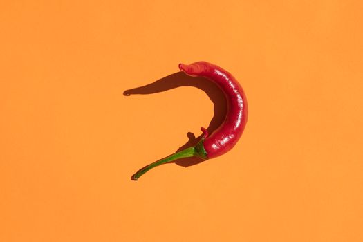 red hot pepper on a yellow background with a hard shadow. High quality photo