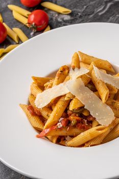 Penne pasta with a spicy sauce, chili pepper and grated parmesan cheese