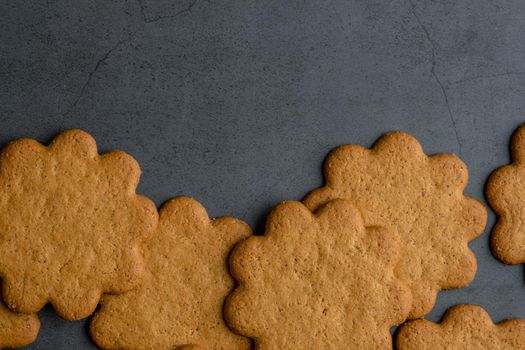 Fresh ginger biscuits piled on dark stone background