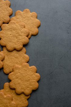 Fresh ginger biscuits piled on dark stone background