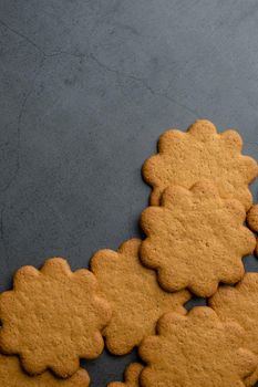 Fresh ginger biscuits piled on dark stone background