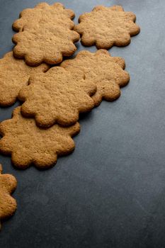 Fresh ginger biscuits piled on dark stone background