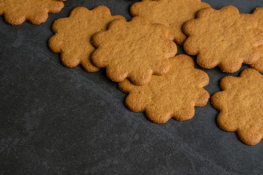 Fresh ginger biscuits piled on dark stone background