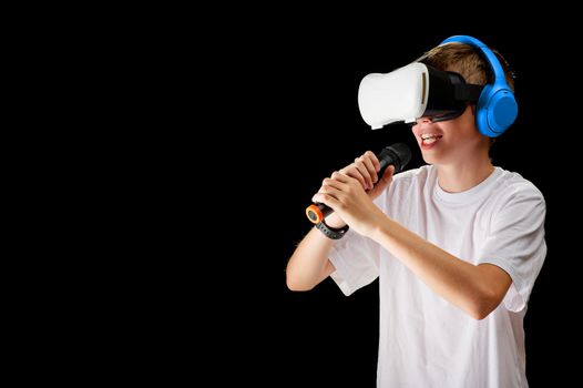Teenager use modern technologies for entertainment or education. Kid in VR glasses, black background. Childrens in VR glasses singing with microphone. virtual Karaoke VR musician concept.