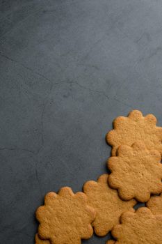 Fresh ginger biscuits piled on dark stone background