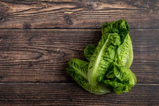 Pile of Fresh mini lettuces on wooden background, copy space