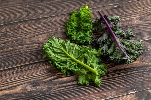 green leafy kale vegetable isolated on wooden table background