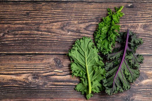 green leafy kale vegetable isolated on wooden table background