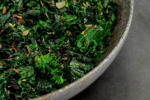 sauteed kale with onion in a pan with olive oil, healthy cooking concept