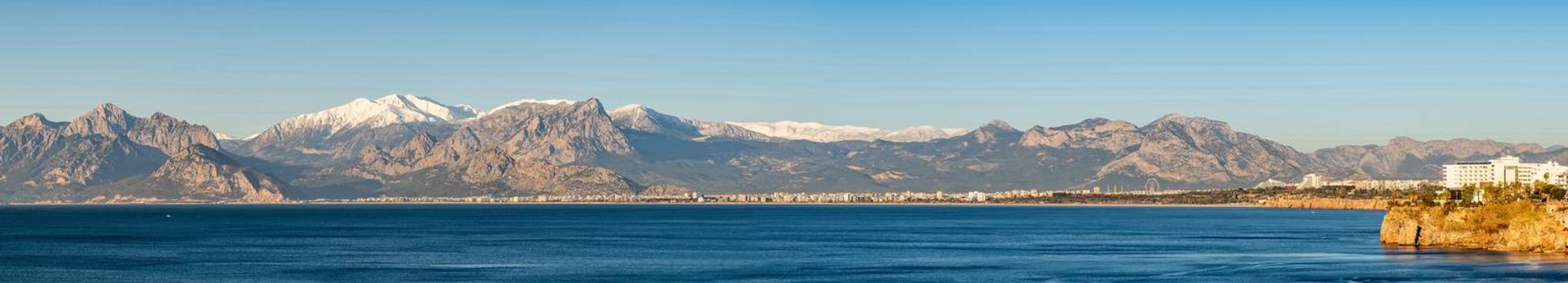 Panoramic view of Antalya on a sunny winter day with sea and snowy mountains