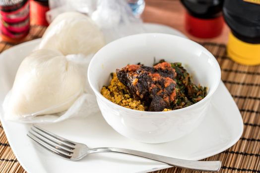 Regional African Food on white plate on wooden background