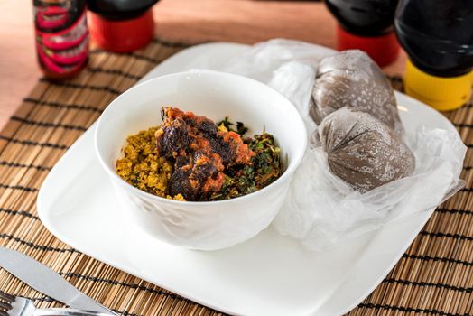 Regional African Food on white plate on wooden background