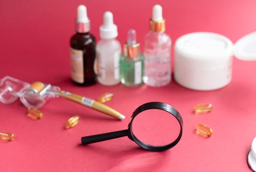 magnifying glass against the background of blurred face serums and dermoroller. The concept of finding the right skin care. High quality photo