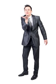 Full body of seductive male in elegant suit looking at camera while sending air kiss isolated on white background in light studio