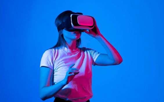 Creative engineer working with virtual reality, young woman testing VR glasses or goggles sitting in the studio room and working with engineering project