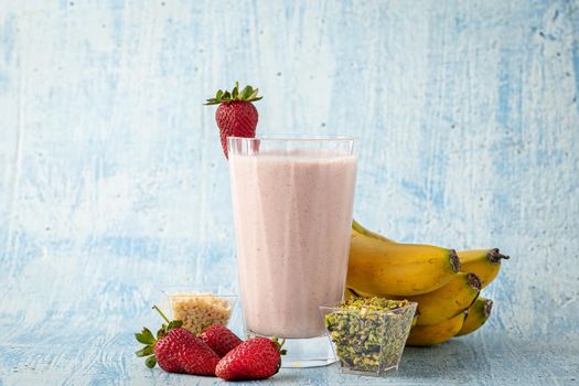 Strawberry and banana cold smoothie on blue background