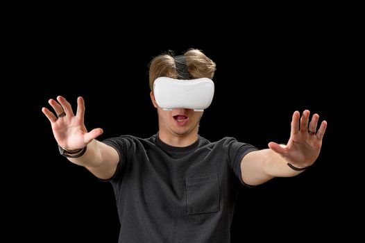 Portrait of a young man with 3D virtual reality glasses. Young man using white virtual reality headset, VR, future, goggles, technology concept on black background.