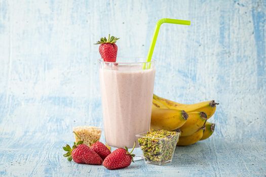 Strawberry and banana cold smoothie on blue background