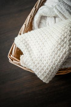 Knitwear, fabric textures and rustic lifestyle concept - Knitted winter clothes in a basket
