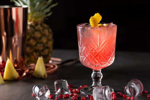 refreshing and light pomegranate and pineapple summer cocktail with ice cubes