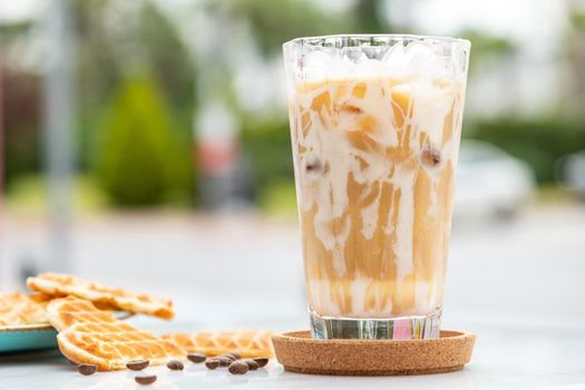 Iced caramel latte coffee in a tall glass with caramel syrup