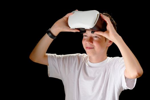 VR Goggles used by a child. Concept of new technology, gaming, remote education, virtual reality. Metaverse world through VR glasses. boy in Virtual reality headset isolated on black background