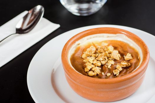 Turkish Sutlac or Oven Rice Pudding with hazelnuts in clay bowl.