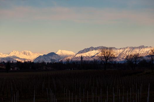 View of the Italian countryside with alp mountains on the background in the winter season