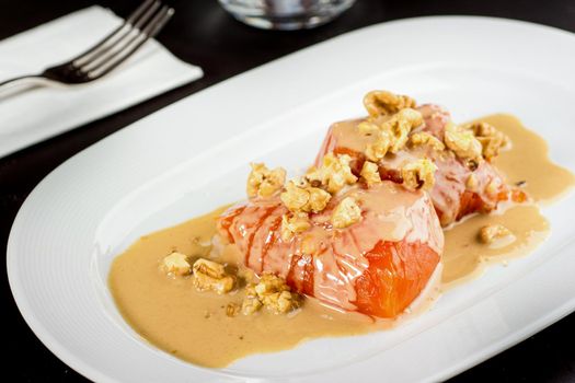 Pumpkin dessert with tahini and walnuts on a white porcelain plate