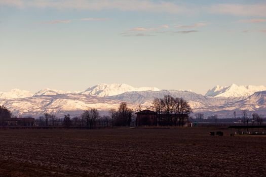 View of the Italian countryside with alp mountains on the background in the winter season