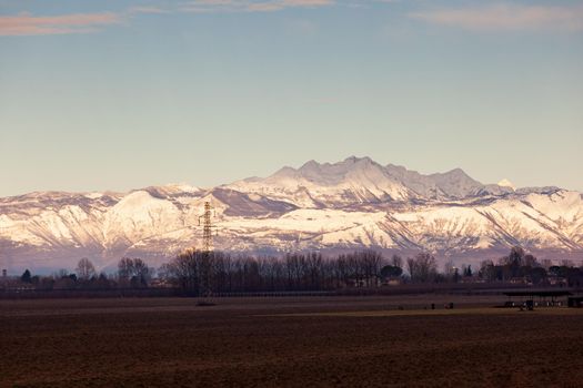 View of the Italian countryside with alp mountains on the background in the winter season