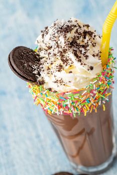 Cream and chocolate milkshake on blue background