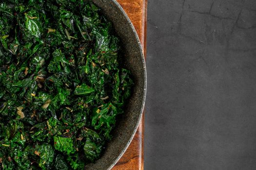 sauteed kale with onion in a pan with olive oil, healthy cooking concept