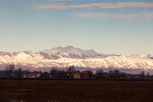 View of the Italian countryside with alp mountains on the background in the winter season