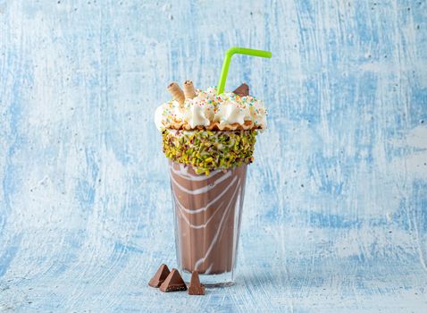 Cream and chocolate milkshake on blue background