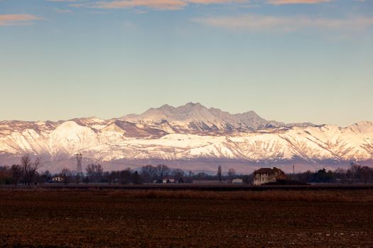 View of the Italian countryside with alp mountains on the background in the winter season