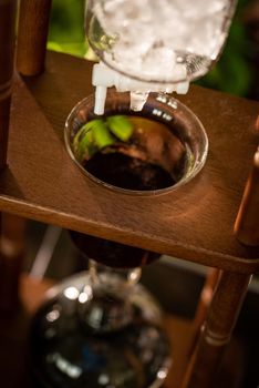 cold drip coffee tower with soft-focus and over light in the background