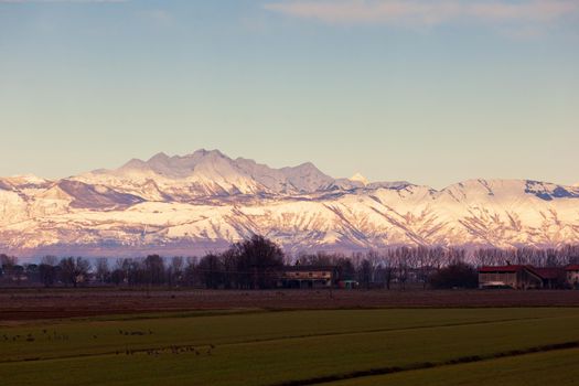 View of the Italian countryside with alp mountains on the background in the winter season