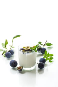 sweet homemade yogurt with fresh plum slices in a glass isolated on white background
