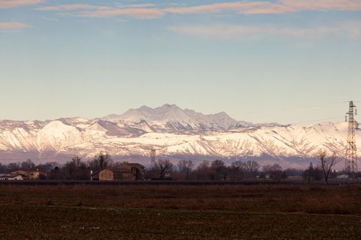 View of the Italian countryside with alp mountains on the background in the winter season