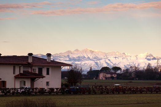 View of the Italian countryside with alp mountains on the background in the winter season