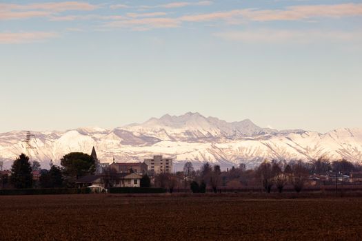 View of the Italian countryside with alp mountains on the background in the winter season